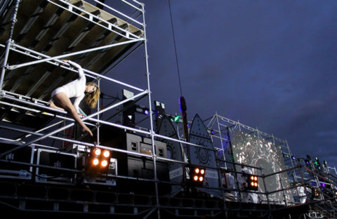 An image of an acrobatic woman using scaffold during her performance.